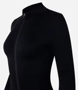 Campera deportiva de corte ajustado, confeccionada en tejido seamless de poliamida y elastano. Presenta cuello alto, cierre frontal con cremallera y textura acanalada.