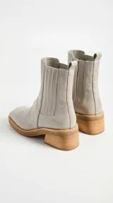Bota tipo chelsea de cuero color suela, con paneles elásticos laterales, puntera cuadrada y suela de goma con taco de madera de diseño geométrico.