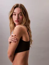 Bralette de diseño minimalista con escote redondo, confeccionado en tejido suave sin costuras con efecto segunda piel. Cuenta con copas con relleno extraíble y tirantes ajustables con el logo de la marca.