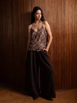 Top de lentejuelas con diseño a cuadros en tonos marrones, rojos y blancos. Cuenta con breteles finos regulables y escote en V.