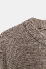 Jersey de punto con cuello redondo y manga larga, con terminaciones en tejido rib en cuello, puños y cintura.