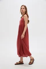 Vestido midi negro de viscosa con cuello cuadrado y tirantes finos ajustables con lazo en los hombros, de corte holgado y diseño fluido.