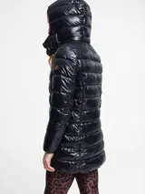 Campera puffer larga de nylon color negro, con cuello alto y capucha desmontable. Tiene cierre frontal con cremallera, bolsillos laterales con cierre y logo redondo en la manga.