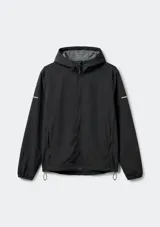 Campera cortaviento de secado rápido color negro, con capucha, cierre frontal completo, bolsillos laterales con cierre y detalles reflectantes en las mangas.