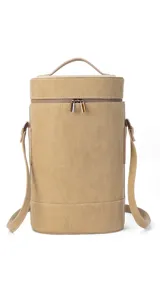 Matera cilíndrica color marrón claro, con cierre superior y correa larga regulable.