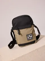 Bandolera Rusty color beige con parte superior negra, confeccionada en ripstop de poliéster. Cuenta con cierre de cremallera, tirador de cordón y logo de la marca en el frente.
