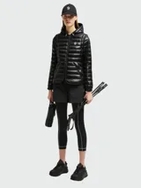 Chaqueta puffer negra con capucha, cierre frontal con cremallera, bolsillos laterales con cremallera y logo de la marca en el pecho.