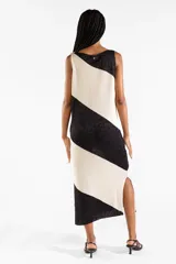 Vestido midi tejido bicolor en negro y beige con brillo sutil, escote bote, diseño sin mangas y abertura lateral en el dobladillo.