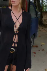 Saco largo de tejido de punto con diseño de chevron, manga larga y cierre frontal mediante cordones entrelazados.