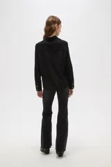 Camisa de poliéster color crema con estampado de pequeños puntos negros, cuello clásico, cierre frontal con botones y mangas largas con puños abotonados.