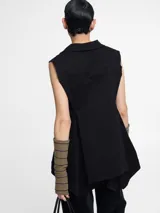 Chaleco sastrero negro con pinzas en la espalda, largo irregular y botones en la delantera.