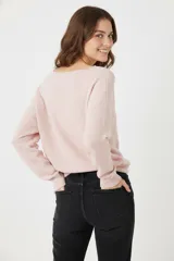 Sweater color crudo de acrílico con cuello a la base y mangas largas.