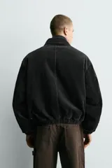 Cazadora de corte relajado confeccionada en pana de algodón con interior acolchado. Presenta cuello solapa, manga larga con puños elásticos y ruedo elástico. Cuenta con bolsillos de plastrón en la parte frontal y cierre con alamares metálicos decorativos sobre una cremallera oculta.