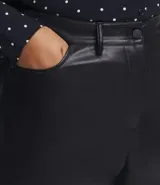 Pantalón flare de tiro alto en material sintético negro, con bolsillos y trabillas en la cintura. Cierre con botón y cremallera. Corte ceñido en caderas y muslos, y acampanado desde la rodilla.