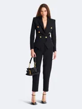 Blazer negro Balmain de corte entallado con doble botonadura y seis botones dorados.