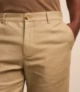 Bermuda masculina de corte recto, color beige, con cintura con trabillas y cierre tradicional. Confeccionada en una mezcla de algodón y lino con textura.