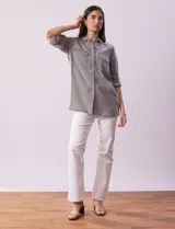 Camisa celeste de tencel con cuello con solapa, abertura central con botones ocultos, bolsillos delanteros y mangas largas regulables con presilla y botón.