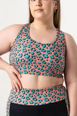 Top deportivo con estampado animal print en tonos coral y celeste, breteles anchos y espalda cruzada con detalle de aros.