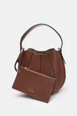 Bolso marrón con forma de saca, detalle de pespuntes en el corte y asa de mano. Incluye correa extraíble para usar como bandolera y cartera con bolsillo extraíble. Cierre con botón imantado.