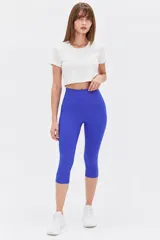 Calza biker azul de tiro alto, confeccionada en poliéster con diseño ajustado al cuerpo que llega por debajo de la rodilla.