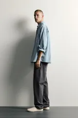 Camisa regular fit de denim de algodón con efecto lavado, cuello solapa y manga larga con puño abotonado. Tiene un bolsillo de parche en el pecho con detalle bordado a contraste y cierre frontal con botonadura.