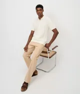 Pantalón cargo de corte recto en color beige, confeccionado en tejido de sarga de algodón. Cuenta con bolsillos laterales y bolsillos cargo con solapa en las piernas, cintura con pasacintos y cierre frontal con botón y cremallera.