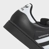 Championes Adidas Superstar II de diseño clásico, color negro con las icónicas tres bandas laterales en blanco. Presentan puntera de goma reforzada, suela de goma al tono y detalle de logo en el talón.