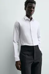 Camisa de hombre color beige claro, de corte slim fit, con cuello italiano, manga larga y cierre frontal de botonadura.