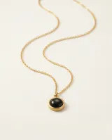 Collar de acero con baño de oro, compuesto por una cadena fina de eslabones y un dije circular con piedra central de color negro.
