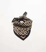 Pañuelo de forma triangular con estampado geométrico en tonos beige y negro, con borde negro sólido.