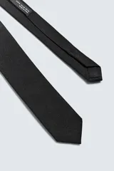 Corbata estrecha de seda color azul marino, con tejido texturizado.