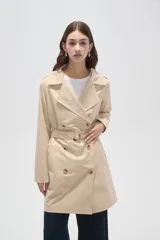 Trinchera de corte clásico, color negro, con cierre frontal de doble botonadura, solapas amplias y cinturón ajustable con hebilla en la cintura.