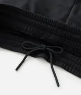 Pantalón deportivo color bordó con rayas blancas laterales, cintura elástica con cordón ajustable, bolsillos laterales y logo pequeño en el muslo.