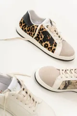 Championes de cuero color blanco con detalle de corona en animal print y talón verde. Cuentan con suela de caucho, lengüeta de gamuza y forro textil, con cierre mediante cordones al tono.