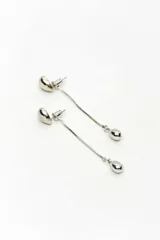 Aros colgantes plateados de metal, con diseño de botón superior con forma ovalada y dije en forma de lágrima suspendido por una fina cadena colgante.