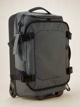 Valija gris con ruedas, manija extensible y múltiples bolsillos con cierre.