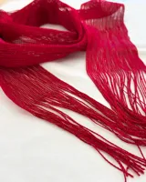 Bufanda de tejido abierto color bordó con flecos en los extremos.