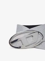 Cinturón plateado con glitter y hebilla ovalada con el logo de Diesel en metal pulido.