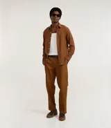 Pantalón de corte recto confeccionado en sarga de algodón con un toque de elastano. Presenta cintura con trabillas para cinturón, cierre tradicional de botón y cremallera, y bolsillos laterales y traseros.