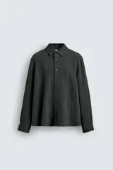 Camisa de corte relajado confeccionada en tejido fluido con mezcla de viscosa. Presenta cuello solapa, cierre frontal con botones y manga larga con puños abotonados.