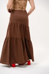 Pollera larga marrón de tiro medio, confeccionada en lino con diseño en niveles y vuelo.