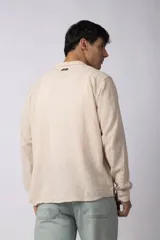 Camisa de manga larga confeccionada en lino, con cuello clásico y cierre frontal de botones. Presenta un diseño de calce suelto y textura suave, ideal para un estilo relajado.