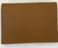 Tarjetero de cuero vacuno color marrón con costuras a contraste. Tiene seis ranuras para tarjetas.