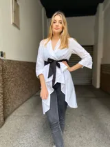 Camisola blanca con escote en V, mangas 3/4 y lazo negro en la cintura.