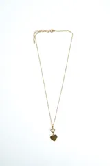Collar dorado con cadena fina y dijes colgantes en forma de corazón, uno superior contorneado y otro inferior sólido.