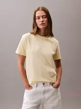 Remera Calvin Klein Jeans de manga corta y cuello redondo, color amarillo claro, con el logo de la marca estampado en el pecho en tono blanco.