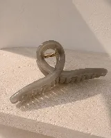 Pinza de pelo con diseño geométrico abierto, en tono gris marmolado.