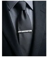 Clip de corbata metálico de color plateado con acabado mate, diseño minimalista con detalles de líneas grabadas en los extremos y un pequeño cristal incrustado en el centro.