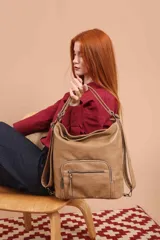 Cartera mochila color tostado, de cuero sintético, con compartimento principal amplio y bolsillos frontales con cierre. Tiene correas ajustables y asa superior para llevar al hombro o como mochila.