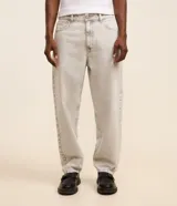 Pantalon de jean gris con lavado deslavado, de corte baggy y silueta holgada. Cuenta con bolsillos al frente y atras, y cierre de boton y cremallera.